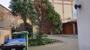 a green trash can sitting in front of a building at Zuhause auf Zeit in Gera
