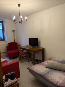 a room with a bedroom with a desk and a television at Zuhause auf Zeit in Gera