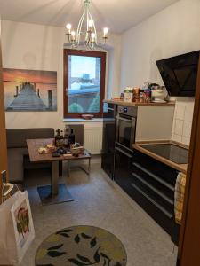 a living room with a table and a kitchen at Zuhause auf Zeit in Gera