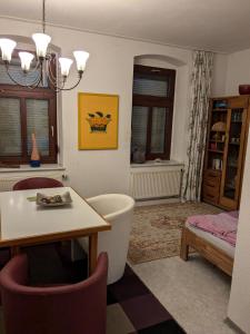 a living room with a table and a bed at Zuhause auf Zeit in Gera +2 photos