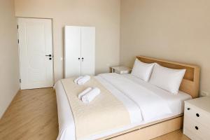 a bedroom with a bed with two towels on it at Miassine Boutique Hotel in Gyumri