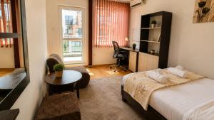 a bedroom with a bed and a desk and a table at City Centre Room Near Everything in Varna City