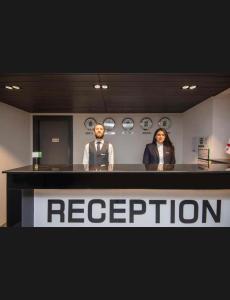 a man and a woman standing behind a reception desk at Aparthotel Room 107 at Orbi Palace in Bakuriani in Bakuriani +25 photos