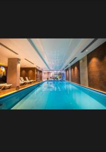 a large swimming pool in a hotel building at Aparthotel Room 107 at Orbi Palace in Bakuriani in Bakuriani