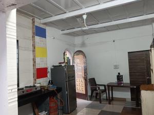 a kitchen with a refrigerator and a table with a chair at White House KMCT in Kapūrwāhāl