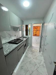 a white kitchen with a stove and a sink at Dar l Bihar in Al Hoceïma