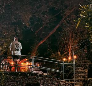 a man standing on a fence at night at Ohana in Coron +2 photos