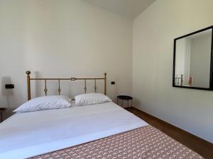a bed with two pillows and a mirror in a room at Casa Ninni in Casalino