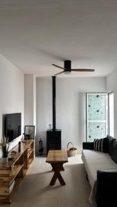 a living room with a couch and a ceiling fan at El Mirador del Asno in El Bosque