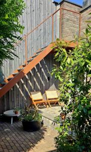 two chairs sitting on a patio next to a wooden fence at Auberge A gen Kirk B&B in Vijlen