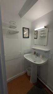 a white bathroom with a sink and a mirror at Hôtel Restaurant de la Place in Saint-Jean-dʼAngély +56 photos