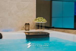 a tray of green grapes sitting on the edge of a swimming pool at Villa Grande Terrace Jacuzzi Suite in Bugojno