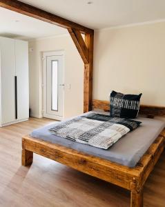 a bed with a wooden frame in a room at Ferienwohnungen Soldanski in Loddin