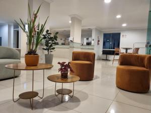 a lobby with two tables and two chairs at Suíte Lari in Caldas Novas
