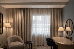 a hotel room with a chair and a window at Radisson Blu Hotel, Liverpool in Liverpool