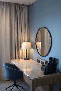 a desk with a lamp and a mirror and a chair at Radisson Blu Hotel, Liverpool in Liverpool