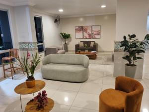 a living room with a couch and chairs at Suíte Lari in Caldas Novas