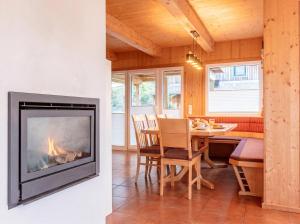 a fireplace in a living room with a dining room table at Almdorf Hohentauern by ALPS RESORTS in Hohentauern