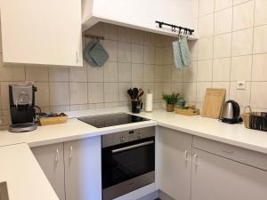 a kitchen with white cabinets and a stove top oven at agroOBERIBA in Płatkownica +23 photos