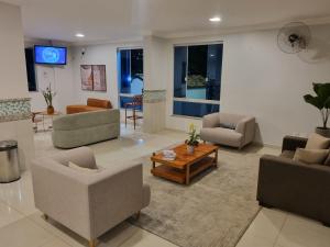a living room with couches and chairs and a table at Suíte Lari in Caldas Novas