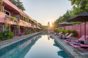 a pool at a resort with lounge chairs at PinkCoco Gili Trawangan - Constant Surprises - for Cool Adults Only in Gili Trawangan