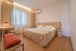 a hotel room with a bed and a table and a desk at Apartment Na broju3 in Krk