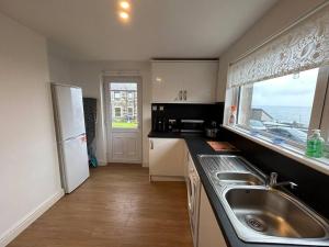 a kitchen with a sink and a window at Carley's House - Macduff Seaside Escape in Macduff
