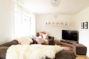 a person laying on a couch in a living room at Carley's House - Macduff Seaside Escape in Macduff