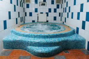 a jacuzzi tub in a tiled bathroom at Pensiunea Praid - Parajd Panzió in Praid +106 photos