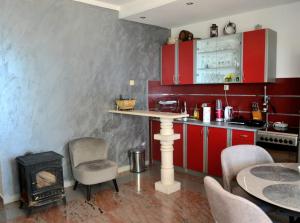 a kitchen with red cabinets and a stove at Holiday house Ogi in Bar +29 photos