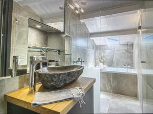 a bathroom with a stone sink and a tub at Amazing apartment with view in Kanoni