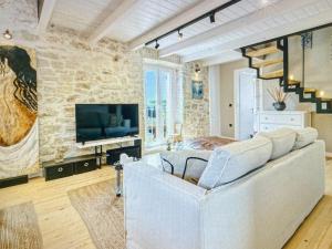 a living room with a couch and a stone wall at Amazing apartment with view in Kanoni