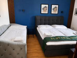 a bedroom with two beds and a blue wall at 21 Star Residence in Darnózseli