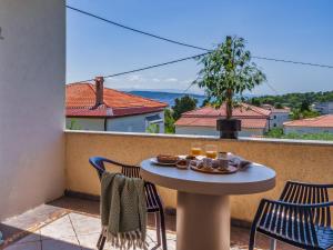 a table and chairs on a balcony with a view at Apartment Na broju3 in Krk