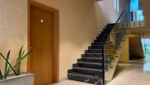 a staircase in a house with a glass railing at Hamsun Shahrah-e-Faisal Extension in Karachi