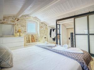 a bedroom with a large bed and a stone wall at Amazing apartment with view in Kanoni