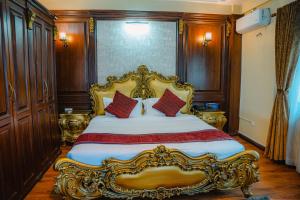 a bedroom with a large gold bed with red pillows at Devi Aura Villa in Burhānilkantha
