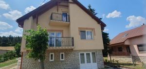 a house with a balcony on the side of it at Fenyves Appartman in Pécsely