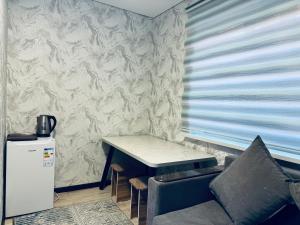 a small table and a chair in a room at Bayaman Guest House in Bokonbayevo
