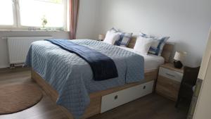 a bedroom with a large bed with a blue blanket at Ferienwohnung am Wald in Warstein