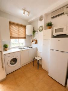 a kitchen with a sink and a washing machine at Mabre view in La Mata