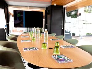a large wooden table with chairs and a television at ibis Styles Lisboa Aeroporto in Lisbon