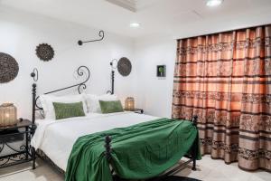 a bedroom with a bed with a green blanket at Luxe Oasis Palma in Quatre Bornes