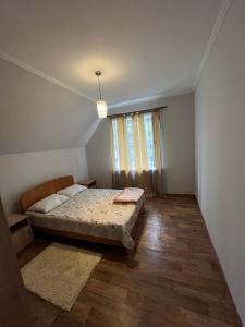 a bedroom with a bed and a large window at Burabay Lake Walk House in Borovoye