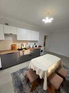 a kitchen with a table and chairs in a room at Burabay Lake Walk House in Borovoye