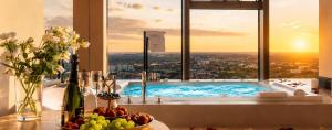 a bathroom with a tub with a view of a city at Apartamenty Sky Tower in Wrocław