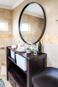 a bathroom with a vanity with a large mirror at Luxe Oasis Palma in Quatre Bornes +4 photos