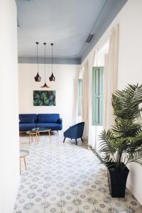 a living room with a blue couch and a plant at Casa Alberola Apartments in Alicante
