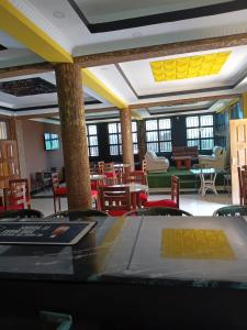 ein Esszimmer mit Tischen und Stühlen und gelben Decken in der Unterkunft Spass Hotel in Eldoret
