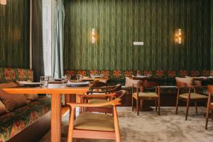 a restaurant with green walls and tables and chairs at Torel Private Collection in Porto